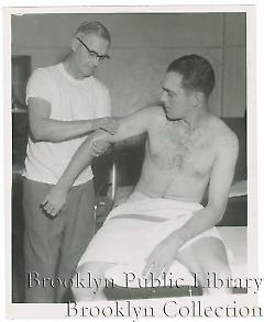 Doc Wendler as Carl Erskine gets his elbow massaged