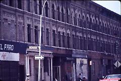 [Townhouses and storefronts on Wilson Avenue, near the intersection with Menahan Street]