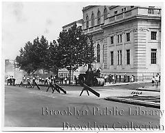 [Former courthouse in Sunset Park with road crew laying asphalt]