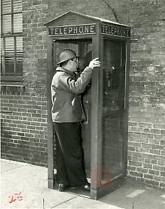 [Yard worker in a telephone booth]
