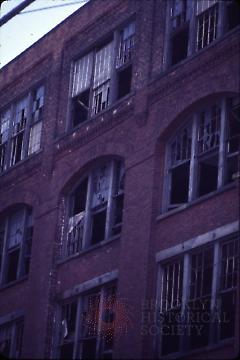 [Building facade with missing or broken windows]