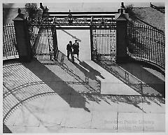 [Aerial view of man and woman entering gate at Pratt Institute]