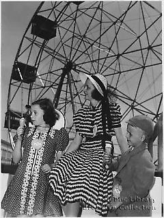 [Woman, two children, and ferris wheel]