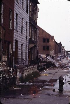 [Side view of damaged townhouses]