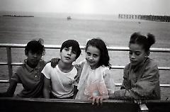 [Four children on the boardwalk]