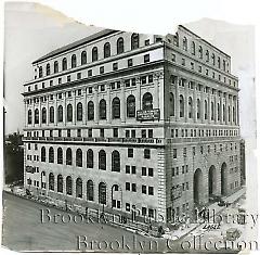 [Aerial view of Central Courts Building at 120 Schermerhorn Street, with construction workers on ground]