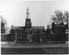 [Woman walking by closed gates of Brooklyn College]