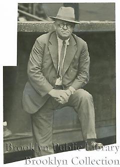 [Wilbert Robinson wearing suit in dugout]