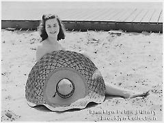 [Young woman sitting on Coney Island beach]