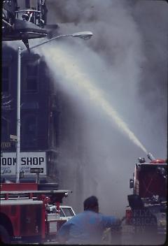 [Firemen entinguishing a fire above a bookstore]