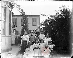 [Group portrait of 11 children in a yard]