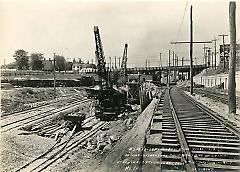 Showing contractors equipment and building of concrete retaining wall bet. 5th & 6th Aves. looking west