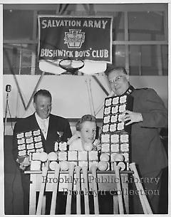 [Boy and two men with baseballs and bats]