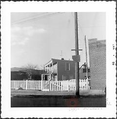 [View of older house obscured by other buildings.]