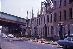 [Bushwick street scene with heavily damaged townhouses in view]