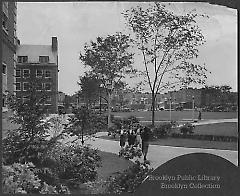[Three female students approaching a fourth on walkway at Brooklyn College]