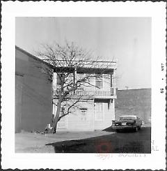 [Portion of older house obscured by other buildings.]