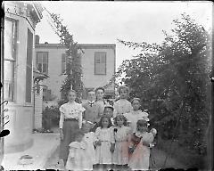 [Group portrait of 11 children in a yard]