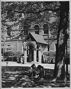[Two women beneath tree before Pratt Institute Library]