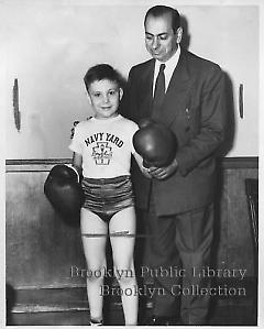 [Boy with boxing gloves standing with man]