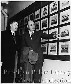 Walter Alston, new Brooklyn manager, shows President John D. Millett of Miami his 1934 Miami baseball team picture