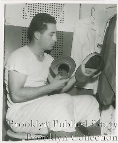 [Carl Furillo trying on baseball cap]