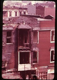 [Back view of a damaged townhouse]