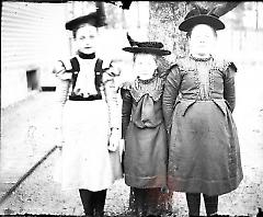 [Three little girls in dresses with hats]