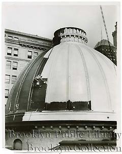 [Worker in harness painting courthouse dome]