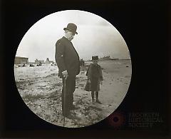 [Man and boy standing on the beach, Coney Island]