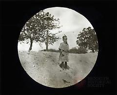 [Boy standing on dirt mound, Flatbush sewer]