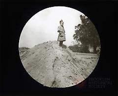 [Boy standing on dirt mound, Flatbush sewer site]